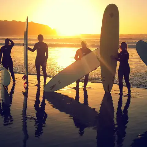 Surfeurs et planches à contre-jour au coucher du soleil
