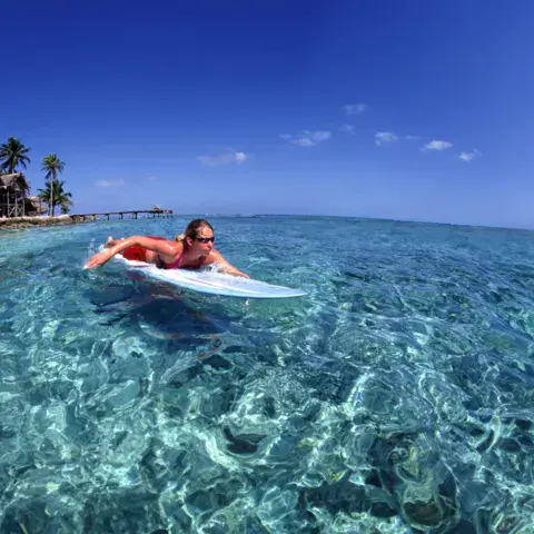 Session de surf en eau turquoise devant l'île