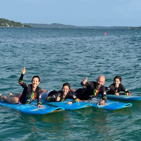 Un petit groupe d'élèves sur leurs planches avec les moniteurs