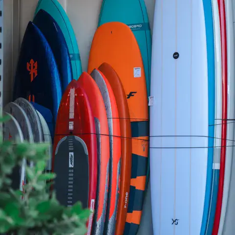 Planches de surf et de paddle rangées en rayon
