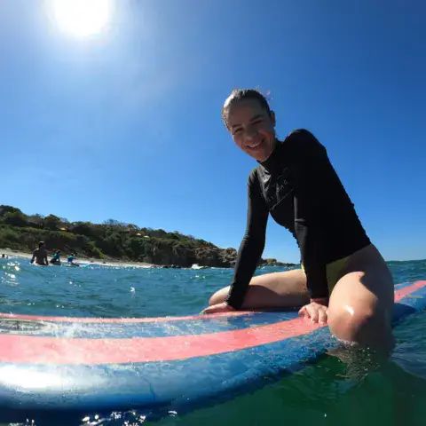 Surfeuse assise sur une planche dans l'eau