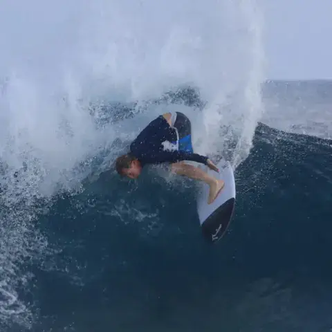 Surfeur qui prend un virage au sommet d'une vague