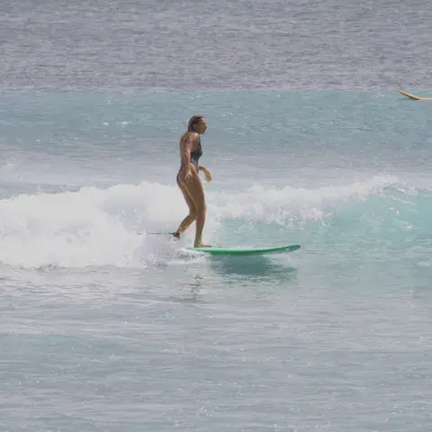 Surfeuse debout sur une planche verte