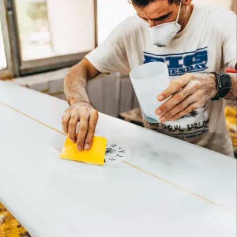 Le shaper au travail sur une planche