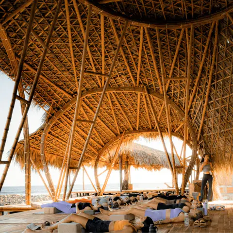 Grande structure en bambou et toit de chaume, tapis de yoga posés au sol
