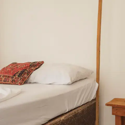 Chambre simple avec lit double et table de chevet en bois