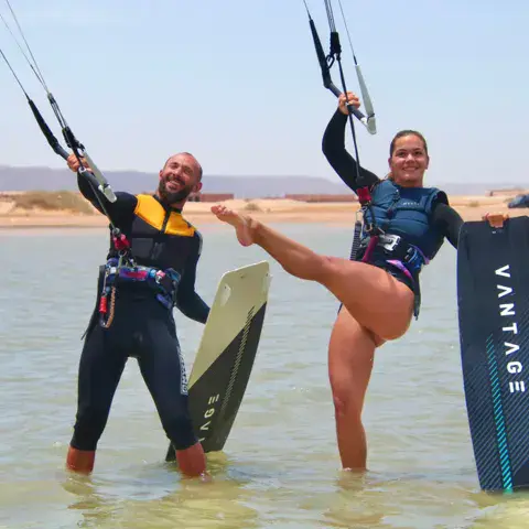 Deux kitesurfeurs avec leurs planches dans l'eau peu profonde