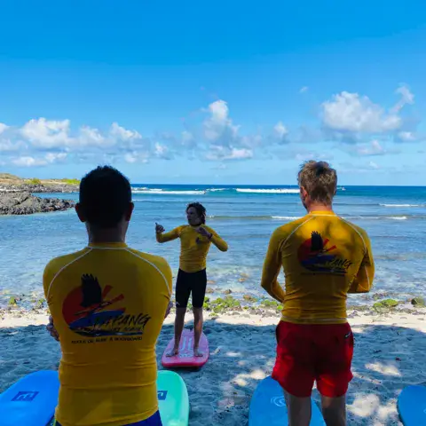 Moniteurs et élèves de dos face à la mer