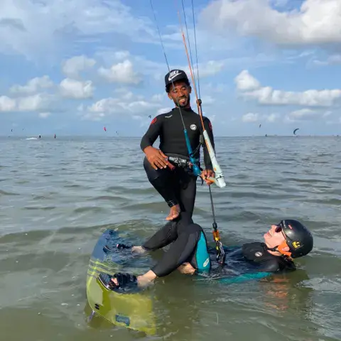 Séance de kitesurf dans l'eau peu profonde de la lagune