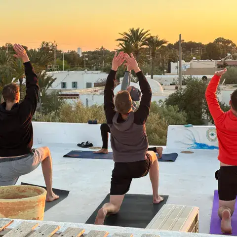 Séance de yoga sur la terrasse de la villa au coucher du soleil