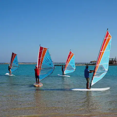 Élèves de windsurf sur une eau plate et peu profonde