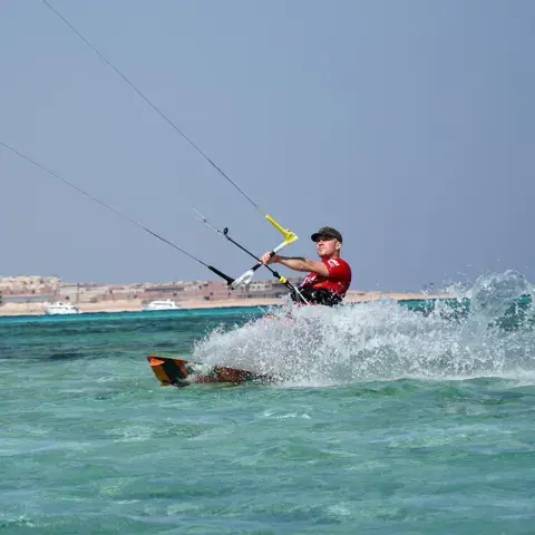 Kitesurfeur qui glisse sur l'eau turquoise