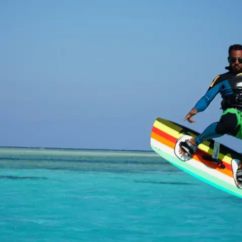 Kitesurfeur en saut au-dessus de l'eau turquoise
