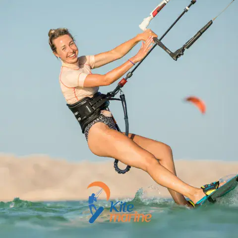 Kitesurfeuse qui glisse sur l'eau turquoise