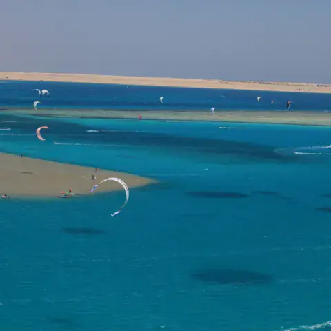 Vue aérienne du plan d'eau turquoise avec des ailes de kite