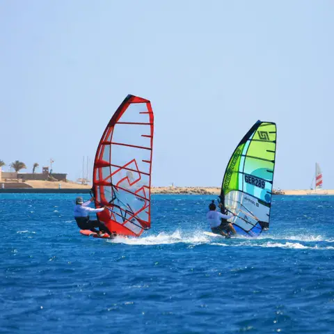 Deux planchistes avec voiles rouge et verte