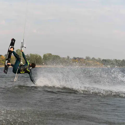 Kitesurfeur en rotation au-dessus de l'eau d'un lac