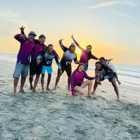 Groupe de l'école sur la plage au coucher du soleil