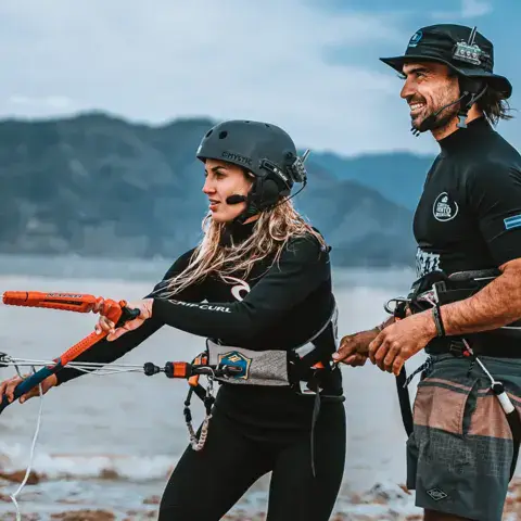 Moniteur et élève avec le matériel sur la plage du lac