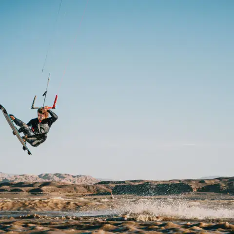 Saut en kitesurf devant les montagnes