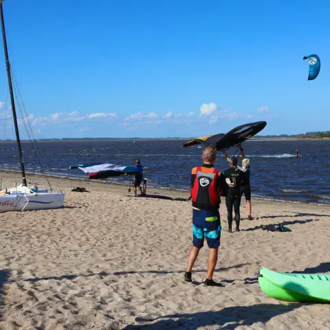 Plage de l'école avec ailes, voiles et kayaks