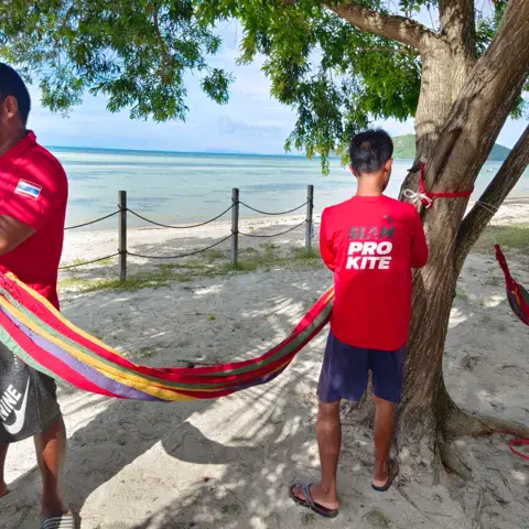 Deux moniteurs à l'ombre des arbres sur la plage