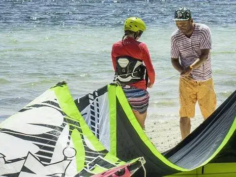 Préparation d'un kite sur la plage avant un cours