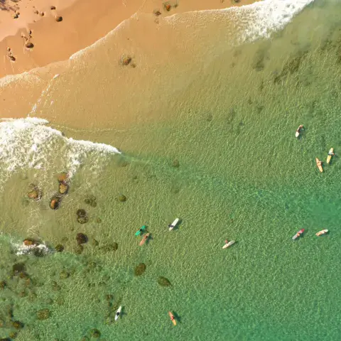 Vue aérienne de surfeurs dans l'eau turquoise