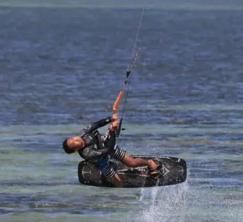 Un kitesurfeur à plat sur l'eau du lagon