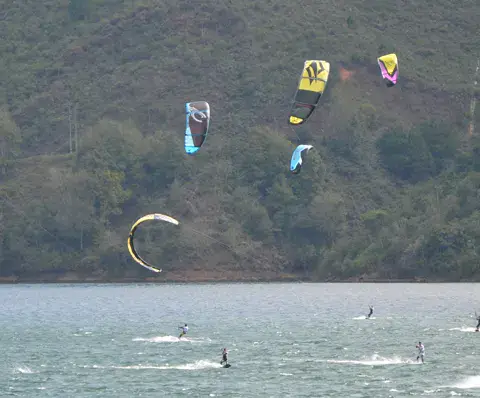 Nombreux kites sur le lac Calima, avec le bateau de l'école