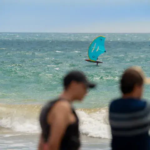 Rider en wing foil près du bord, vu depuis la plage