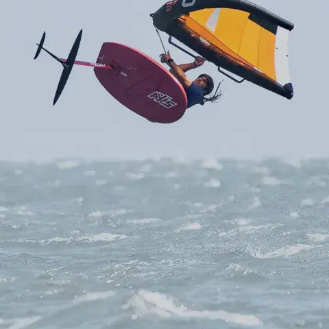 Pratiquant de wing foil en plein saut