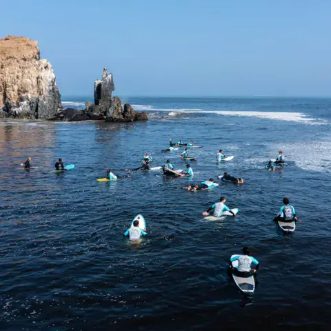 Groupe de surfeurs au line-up, vu du ciel