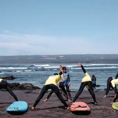 Échauffement collectif sur la plage avant le cours
