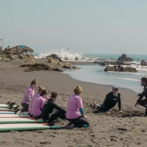 Groupe d'élèves sur la plage avec les planches d'apprentissage