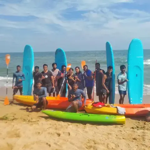 Groupe avec planches et kayaks sur la plage de Kovalam