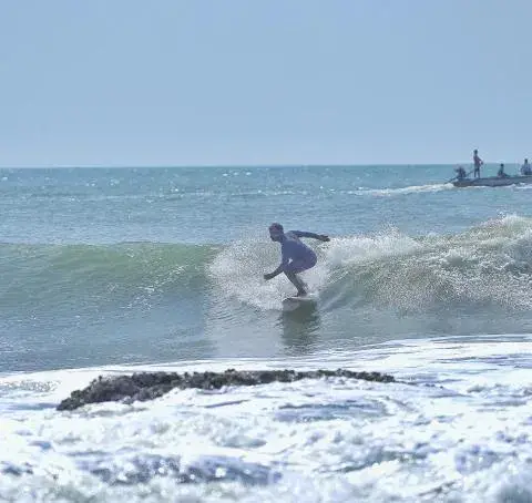 Surfeur sur une vague à Kovalam