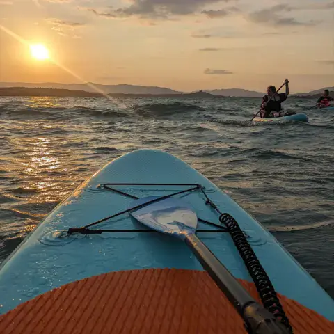 Deux personnes en paddle au coucher du soleil