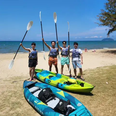 Groupe avec pagaies et kayaks sur la plage