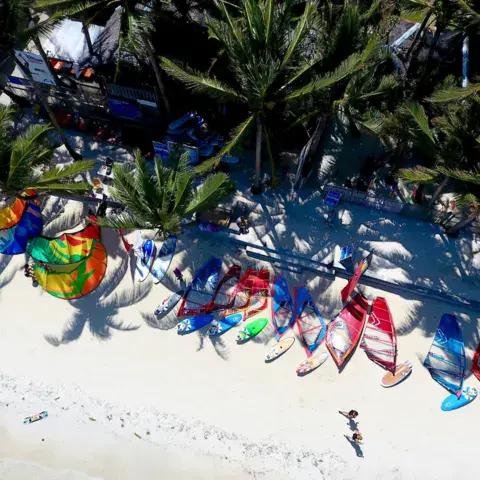 Ailes de kitesurf et planches posées sur le sable