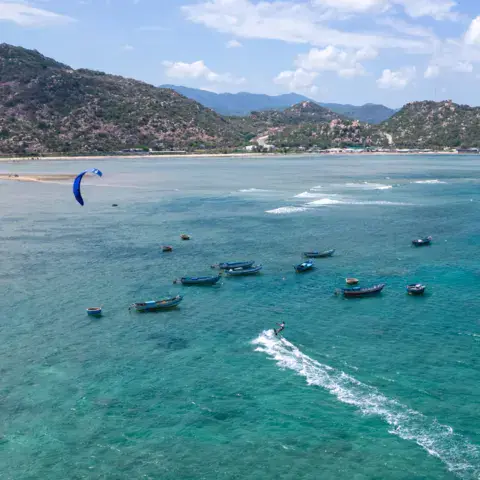 Vue aérienne de la baie avec bateaux et kitesurfeurs