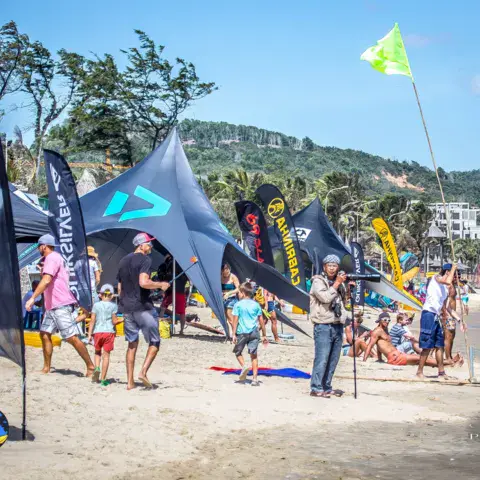 Animation sur la plage avec tentes et banderoles de marques