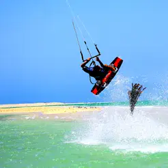 Saut de kitesurf au-dessus de l'eau turquoise