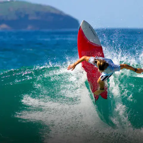 Surfeur en pleine manœuvre sur une vague