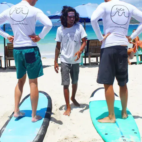 Explications à deux élèves sur la plage avant le cours