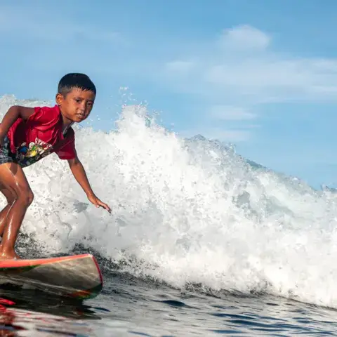 Jeune surfeur sur une vague