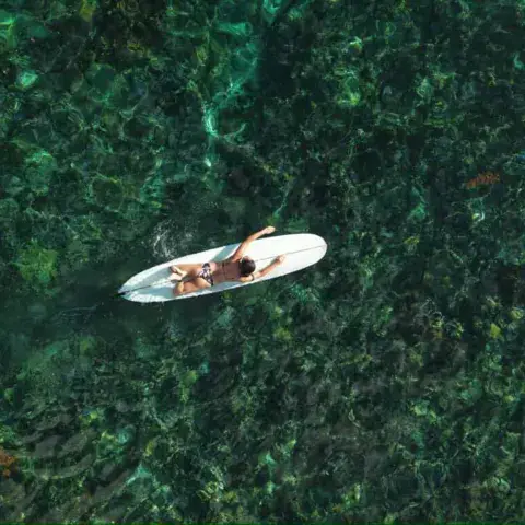 Vue aérienne d'un surfeur allongé sur sa planche