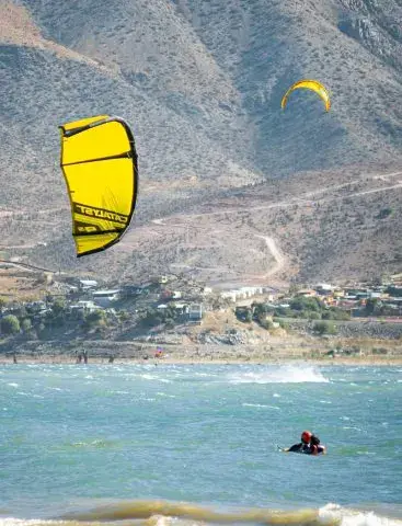 Aile de kite jaune dans le ciel au-dessus de l'embalse, rider sur l'eau