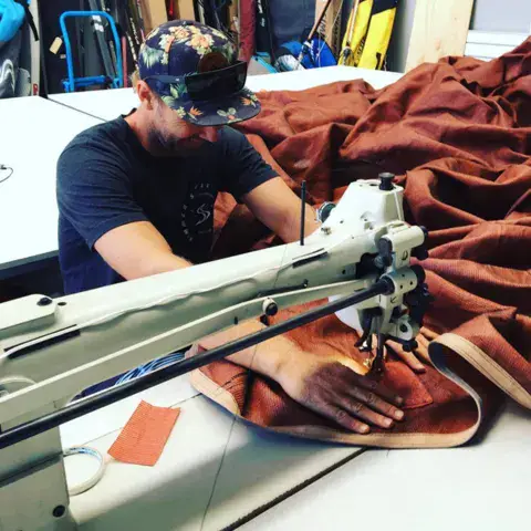 Réparateur à la machine à coudre sur un grand morceau de toile