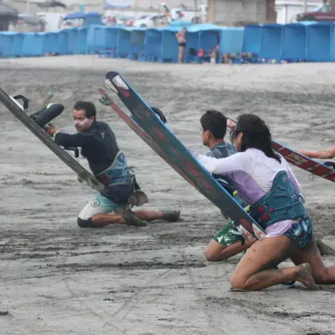 Élèves s'exercent avec leurs planches sur le sable